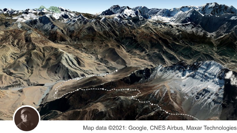 Photo of mountain range with a dotted line cutting through it, indicating a path.
